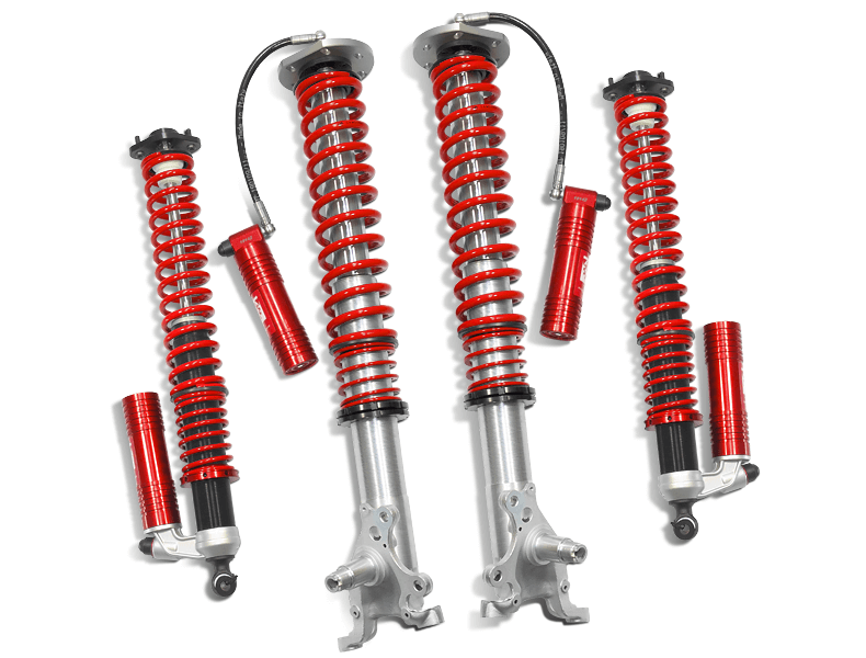 Samsonas stainless steel rally coilovers for BMW E30 with red springs and external reservoirs.