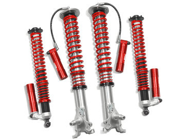 Samsonas stainless steel rally coilovers for BMW E30 with red springs and external reservoirs.